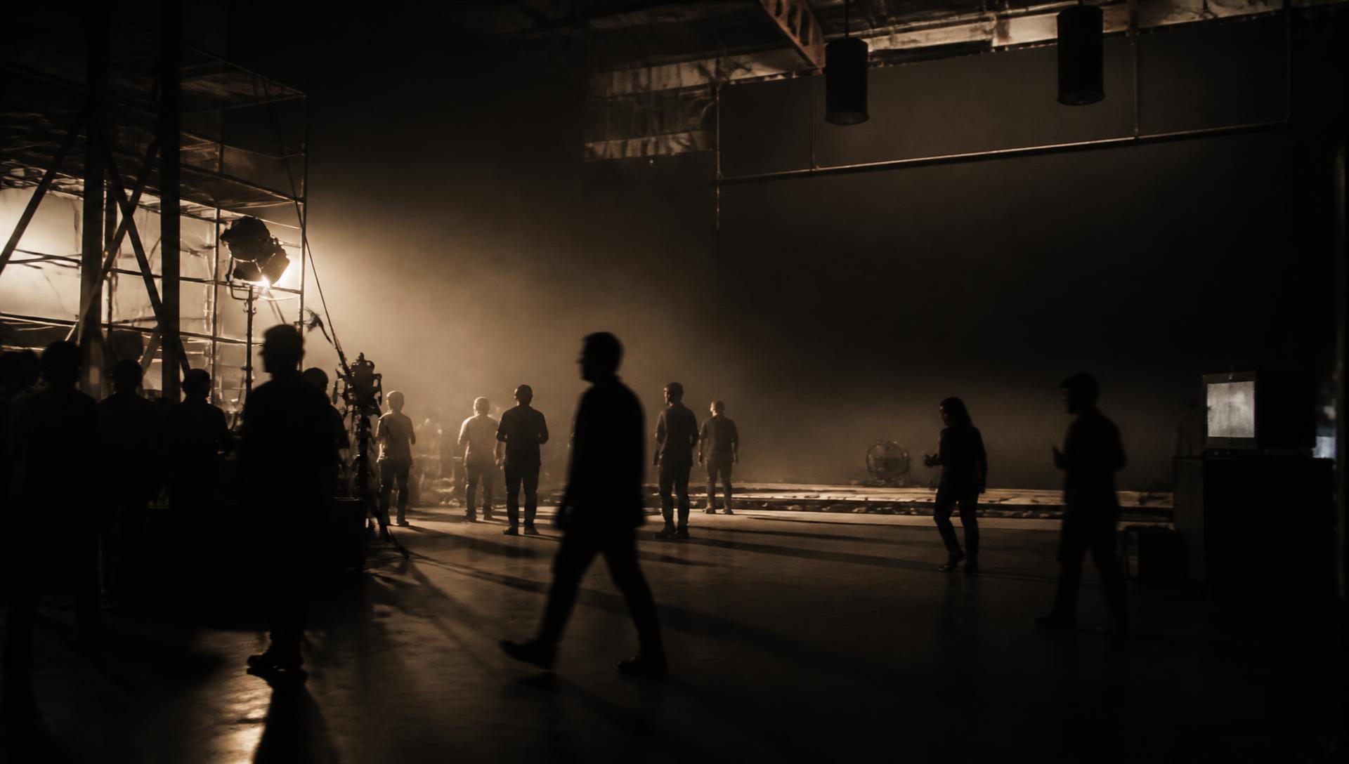 Crew on a hazy soundstage lit by a single warm key light during a SAMA production